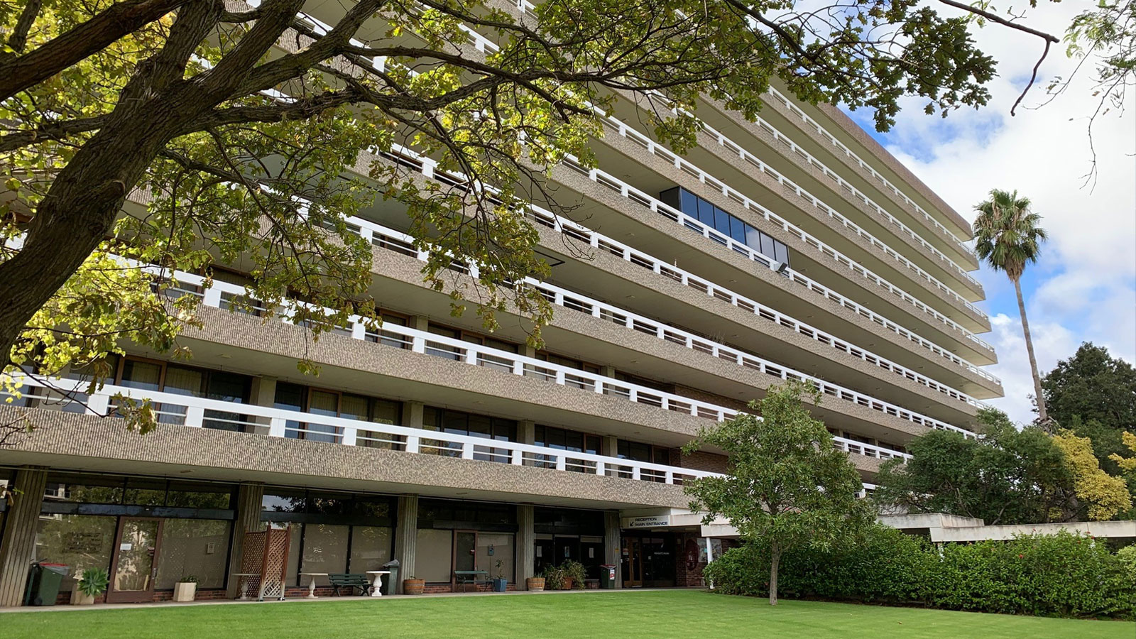 a large mid-20th century multistorey building set in parklands.